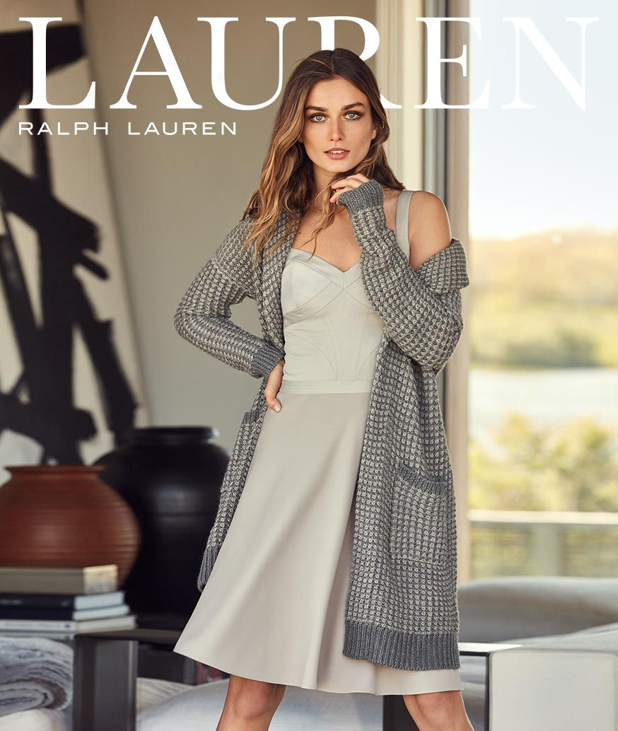 Woman layers long grey knit cardigan over sleek grey sleeveless dress