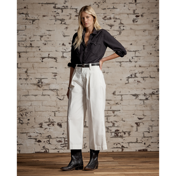 Cropped trousers made with cotton poplin. Inspired by 1940s trousers. Stitched-down pleated front. Buttoned belt loops. Adjustable buckled tabs at the waist. Sanforized to minimise shrinkage.