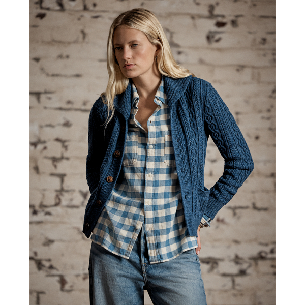 Cable-knit cardigan made with cotton and semi-worsted wool. Designed with a shawl collar and accented with waist patch pockets. Finished with genuine horn buttons.