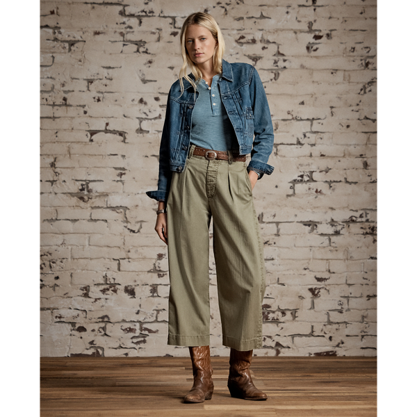 Cropped wide-leg trouser inspired by 1940s trousers. Made with Japanese piece-dyed cotton twill. Features hand-set back flapped pockets and a stitched-down pleated front. Buttoned belt loops and adjustable tabs on the sides. Stonewashed.