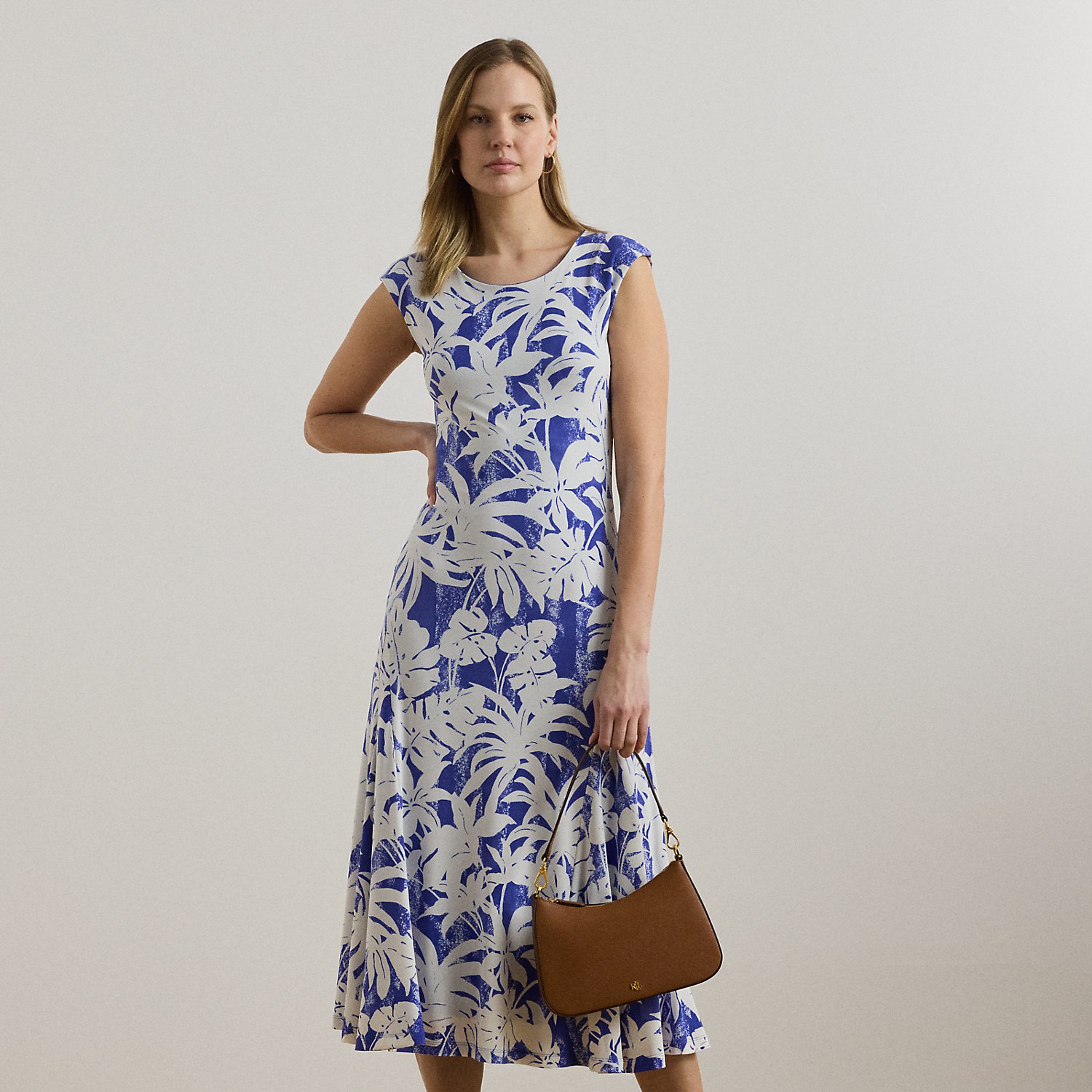 Crafted with smooth stretch jersey for a soft hand and fluid drape, this cap-sleeve dress depicts a palm-frond print in hues of white and blue.