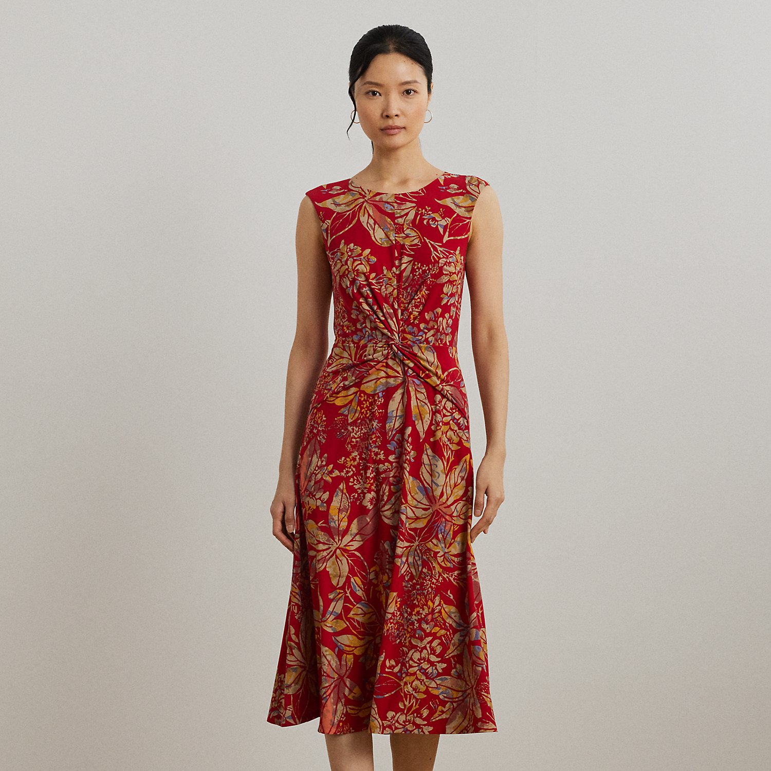 An eye-catching twist-front detail on the bodice serves as the focal point of this cap-sleeve dress, which is crafted from stretch-infused jersey for a soft feel and ease of movement. This version displays a painterly floral motif against a vibrant red backdrop.
