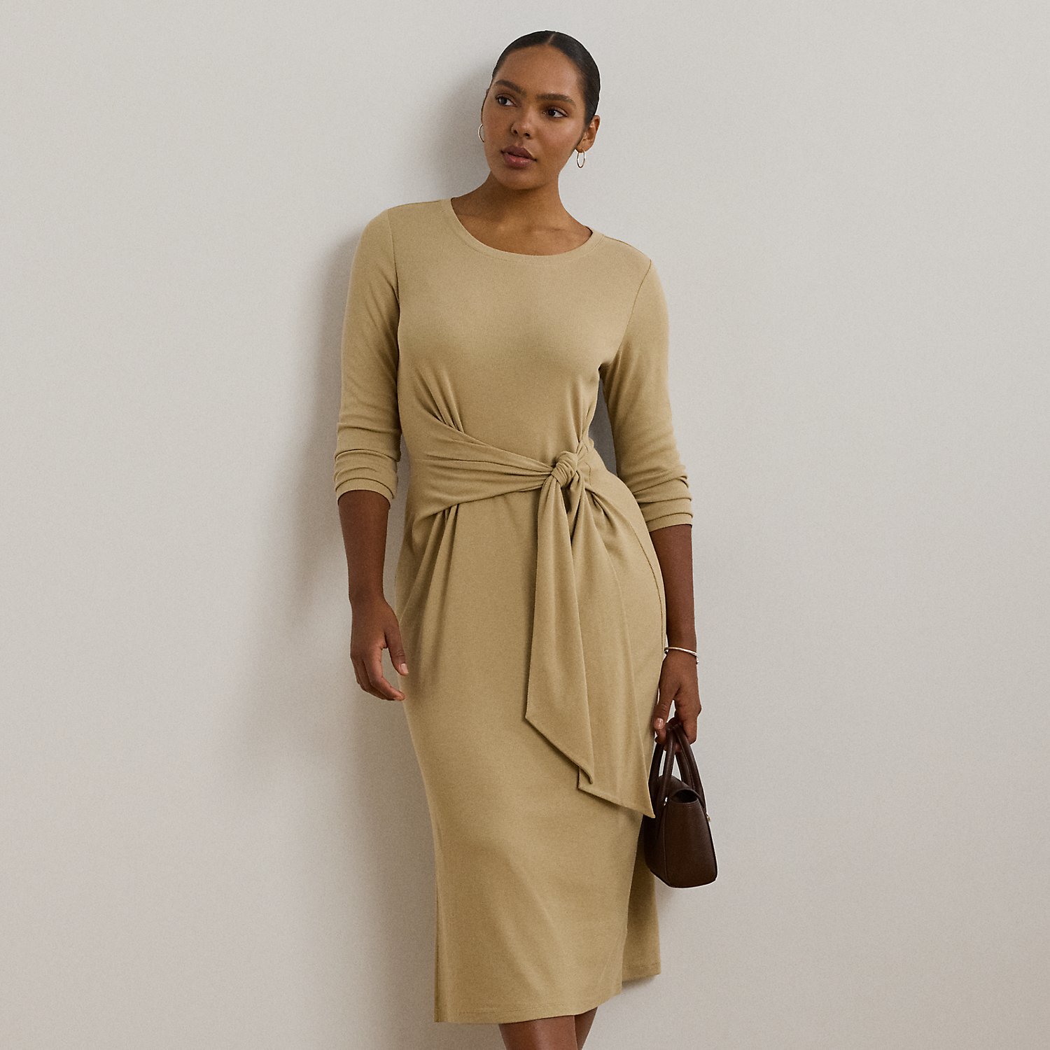 Rib-knit with a soft stretch-cotton blend, this long-sleeve crewneck dress is cut for a slim-fitting silhouette and a calf-grazing midi length. A tie-front design at the waist adds contemporary flare, while a skirt slit affords ease of movement.