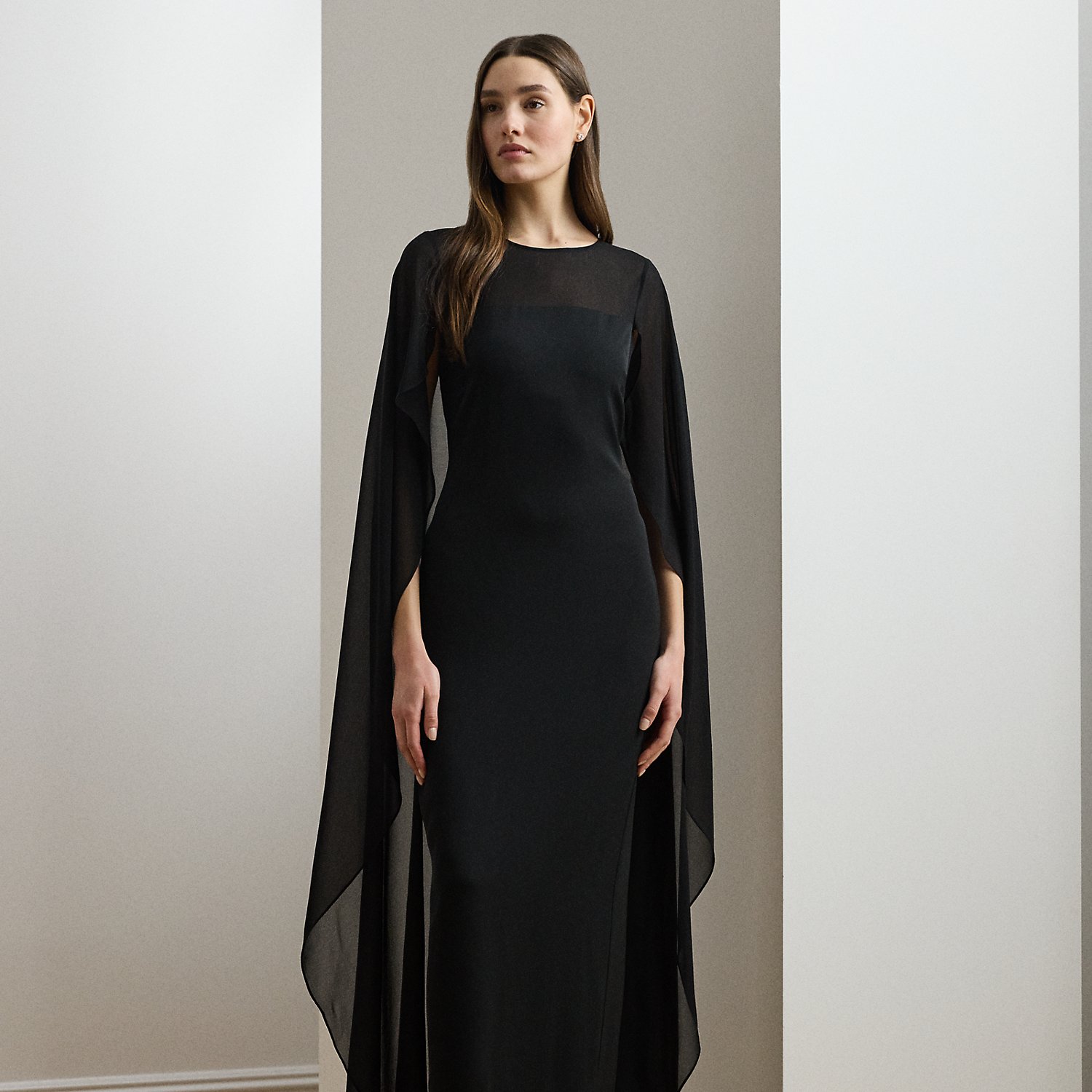 Turn heads at your next event in this glamorous georgette gown, which is designed with a floor-length, semi-sheer cape overlay and a statuesque column silhouette.