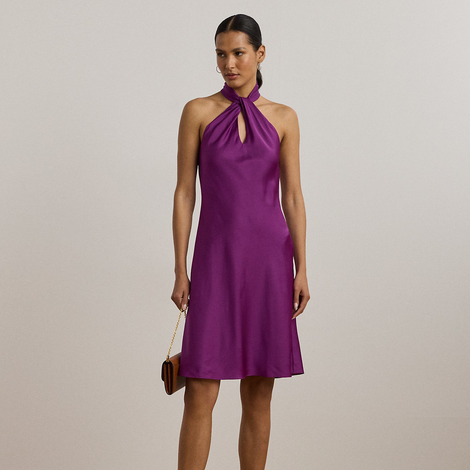 Cut from fluid featherweight charmeuse for a luminous sheen and airy feel, this halter cocktail dress displays an alluring twist-front detail and keyhole on the neckline.