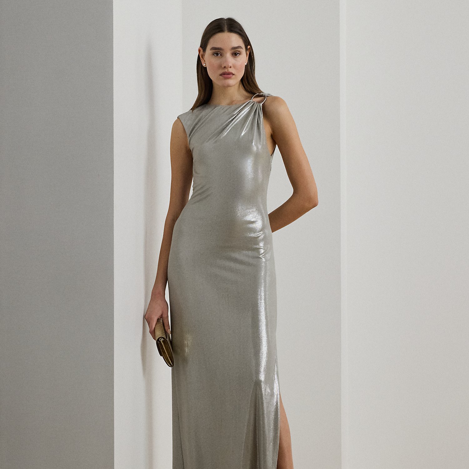 Cut from eye-catching metallic jersey for a fluid drape, this floor-length gown features a statuesque column silhouette and a horseshoe-shaped "LRL"-engraved buckle on the shoulder.