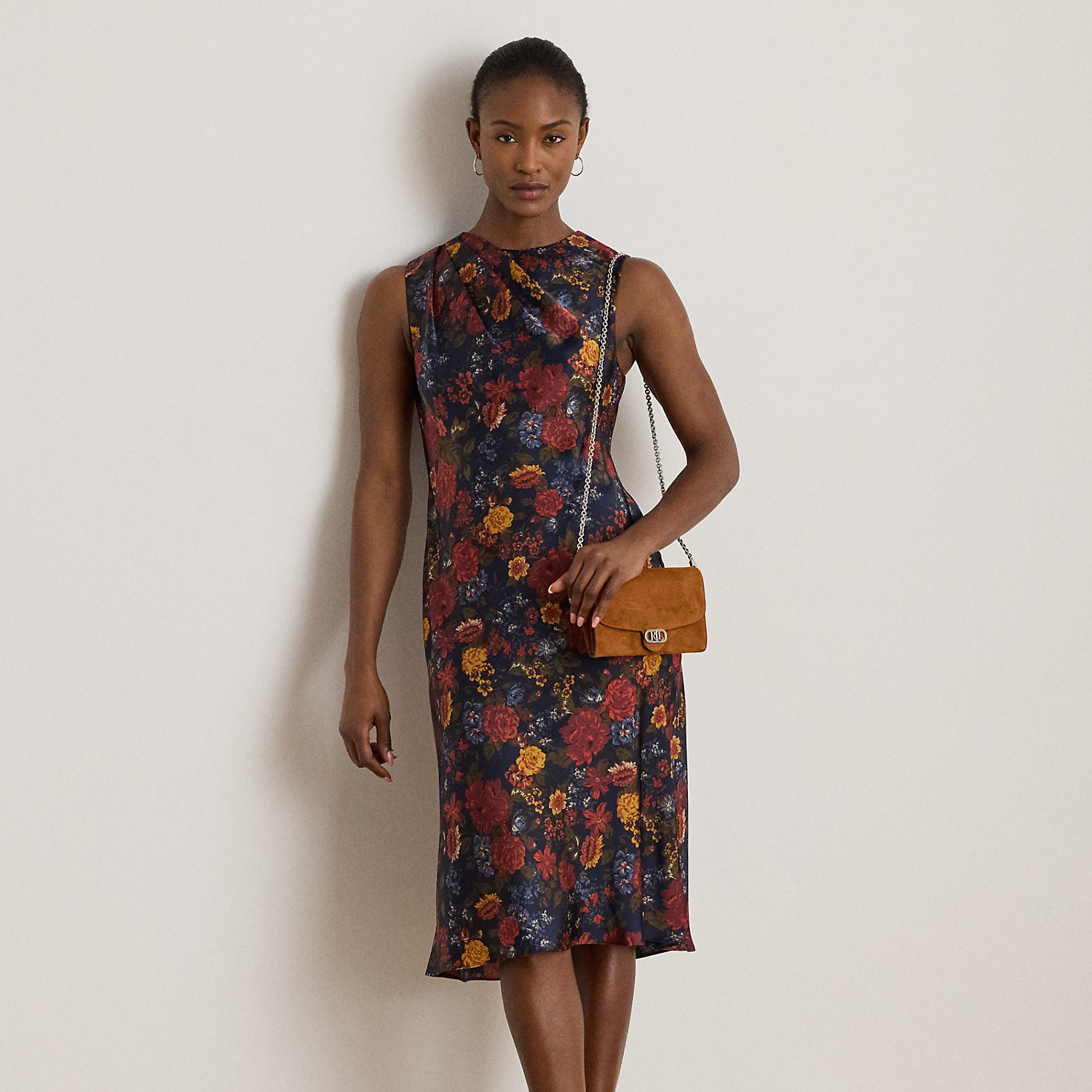 Satin charmeuse brings a beautiful sheen and graceful drape to this sleeveless cocktail dress, which depicts the season's painterly florals against a navy backdrop. Pleats on the shoulder provide an elegant finish.