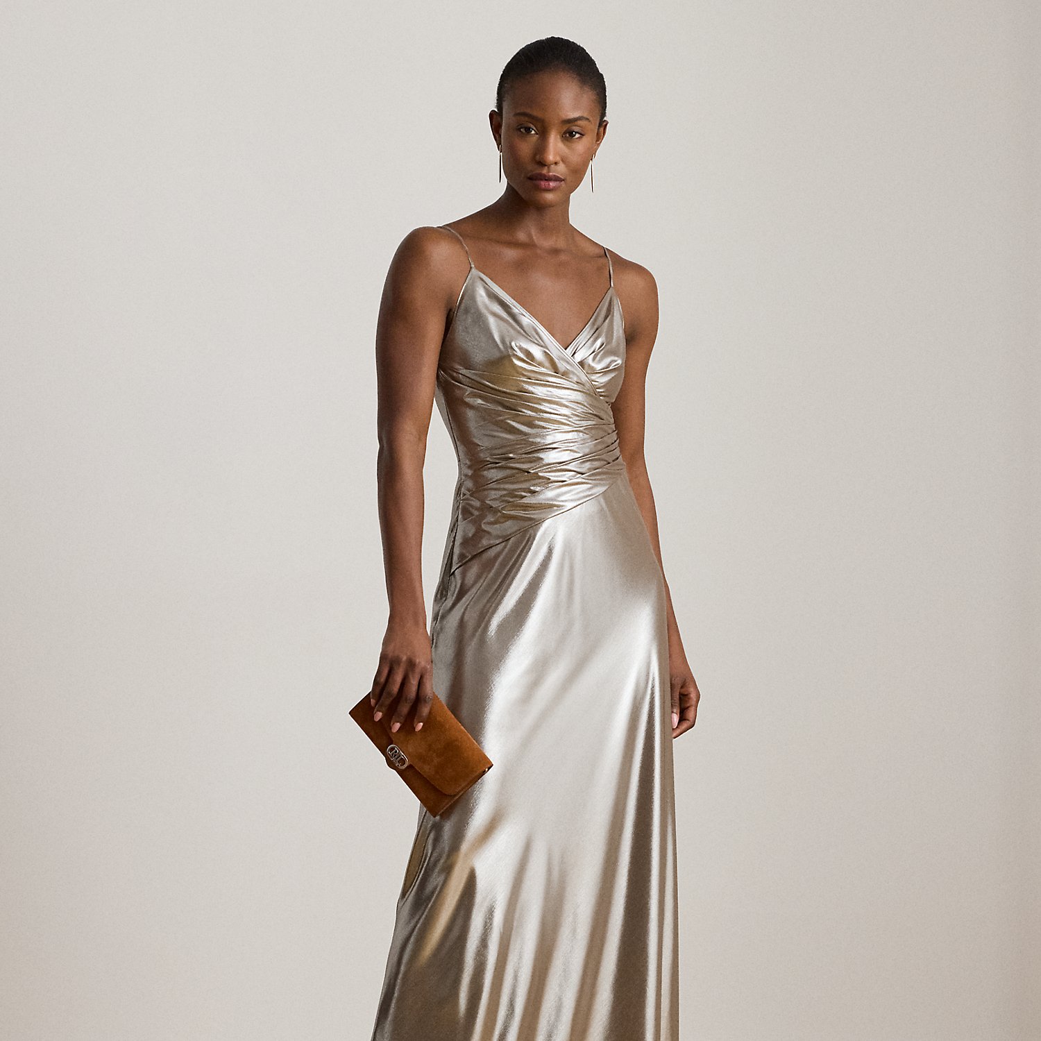 Turn heads in this floor-length sleeveless gown, which features a pleated surplice bodice and fluid metallic chiffon for a lustrous sheen.
