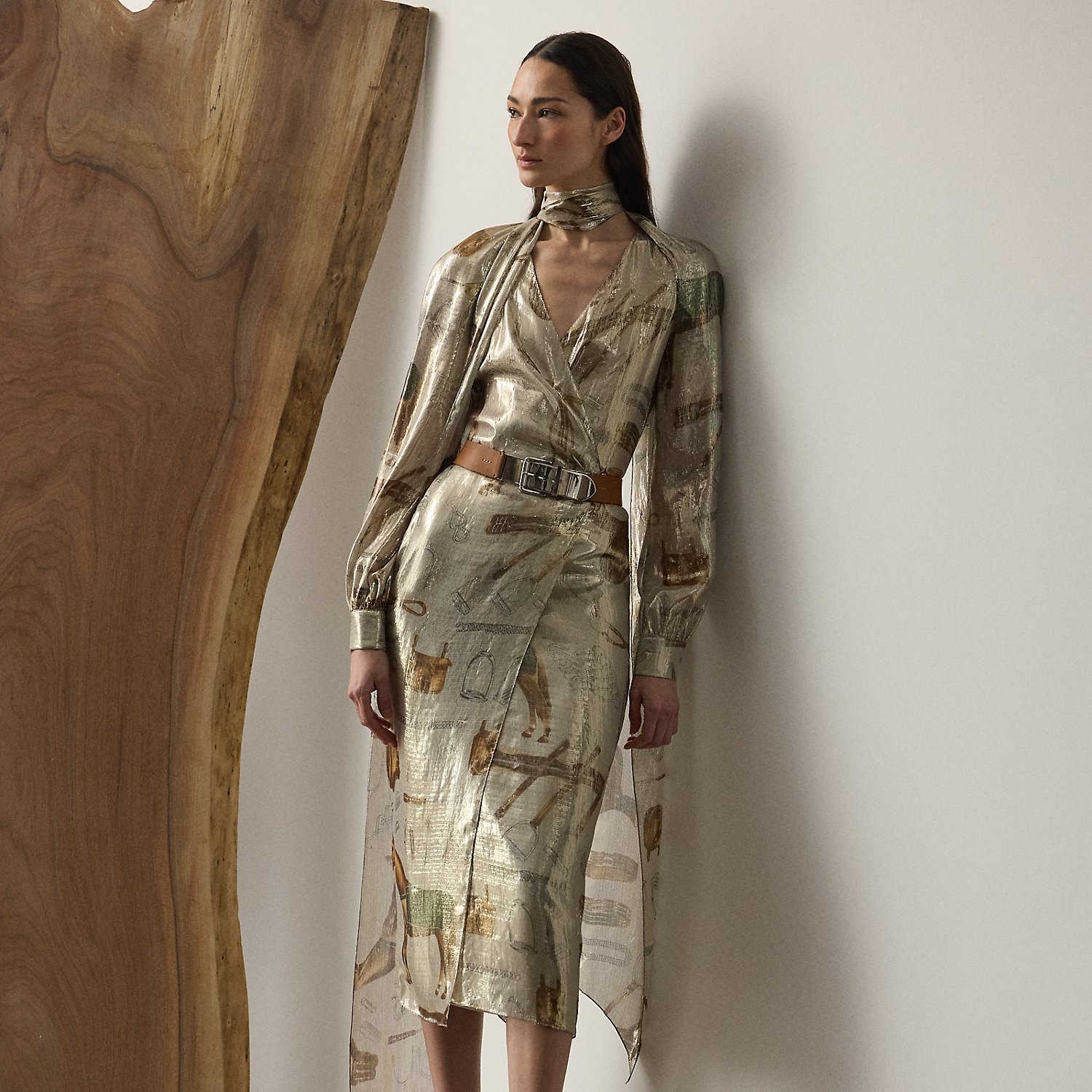 The Terry cocktail dress nods to traditional riding attire – an enduring source of inspiration for Mr Lauren since his earliest designs. Crafted from shimmering, silver-tone lamé fabric, this lean wrap dress is printed with the season's all-over equestrian-inspired motif in a renowned Italian mill in Como and designed with an array of romantic elements, including an engineered scarf, blouson sleeves and genuine mother-of-pearl buttons.
