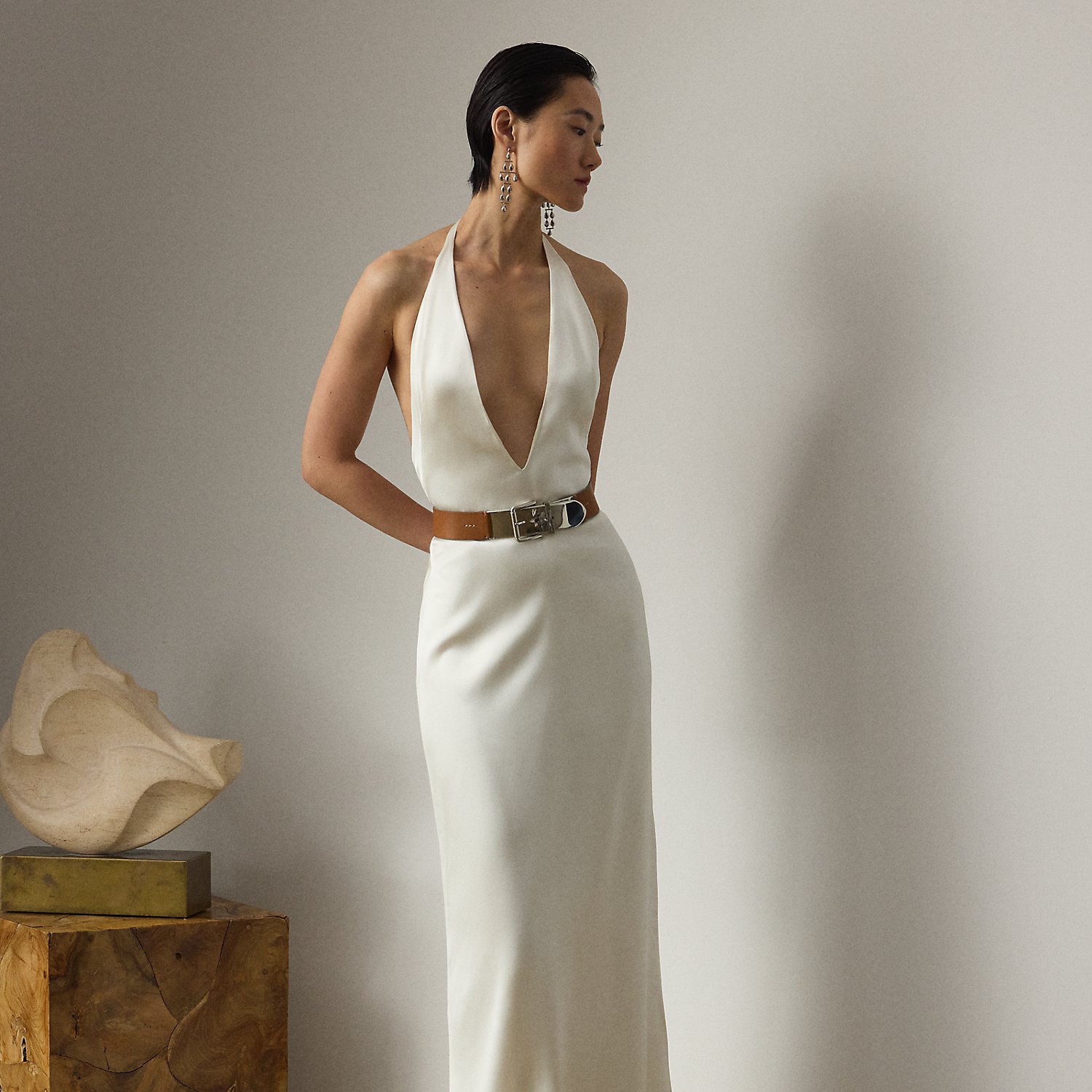 The Cladwell epitomises Mr Lauren's ability to create luxurious looks that are both timeless and modern. Crafted in Italy from full-bodied stretch satin for a fluid drape and perfect sheen, this figure-skimming column dress is distinguished by its dramatic halter silhouette, which easily secures with an "RL"-engraved buckled closure at the centre back of the neck. Featuring a subtle train at the skirt, this evening dress is the definition of understated elegance.