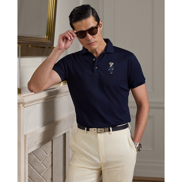 A masterpiece of Italian craftsmanship, this Purple Label Polo shirt elevates casual luxury with its double-mercerised cotton piqué fabric, which ensures exceptional durability and colour brilliance. This version features our beloved Polo Bear in an elegant ensemble that is accented with signature Ralph Lauren Lauren accessories.