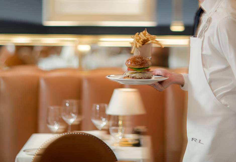 Waiter carrying burger & fries on plate